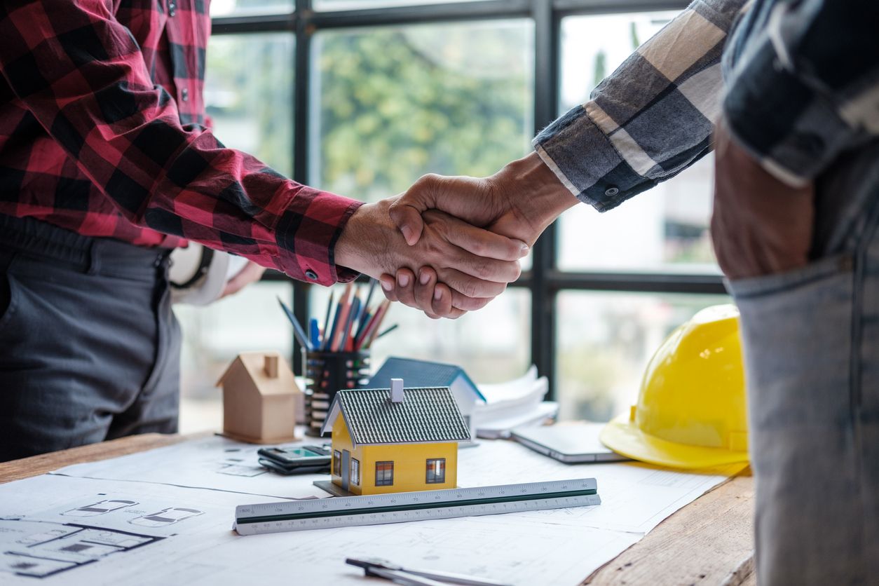 Local contractor and client shaking hands at a Michigan job site